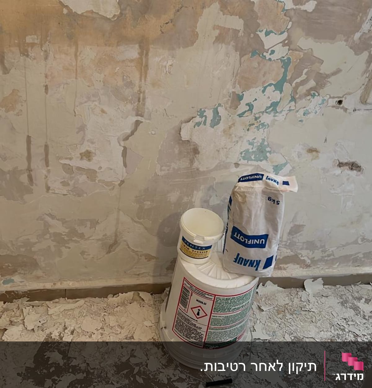 קיר מתקלף עם דלי צבע ושק מלט